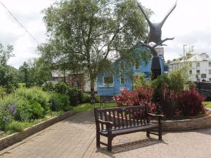 Statue of a red kite and public seating with flower beds in the centre of Llanwrtyd Wells