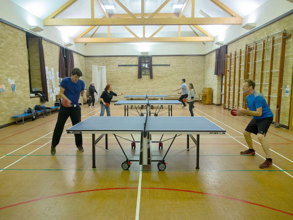 Table tennis players in Llanwrtyd Wells table tennis club in the sports hall.