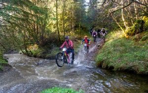 Mountain bikers riding through a deep stream