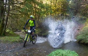Mountain bikers riding through a deep stream