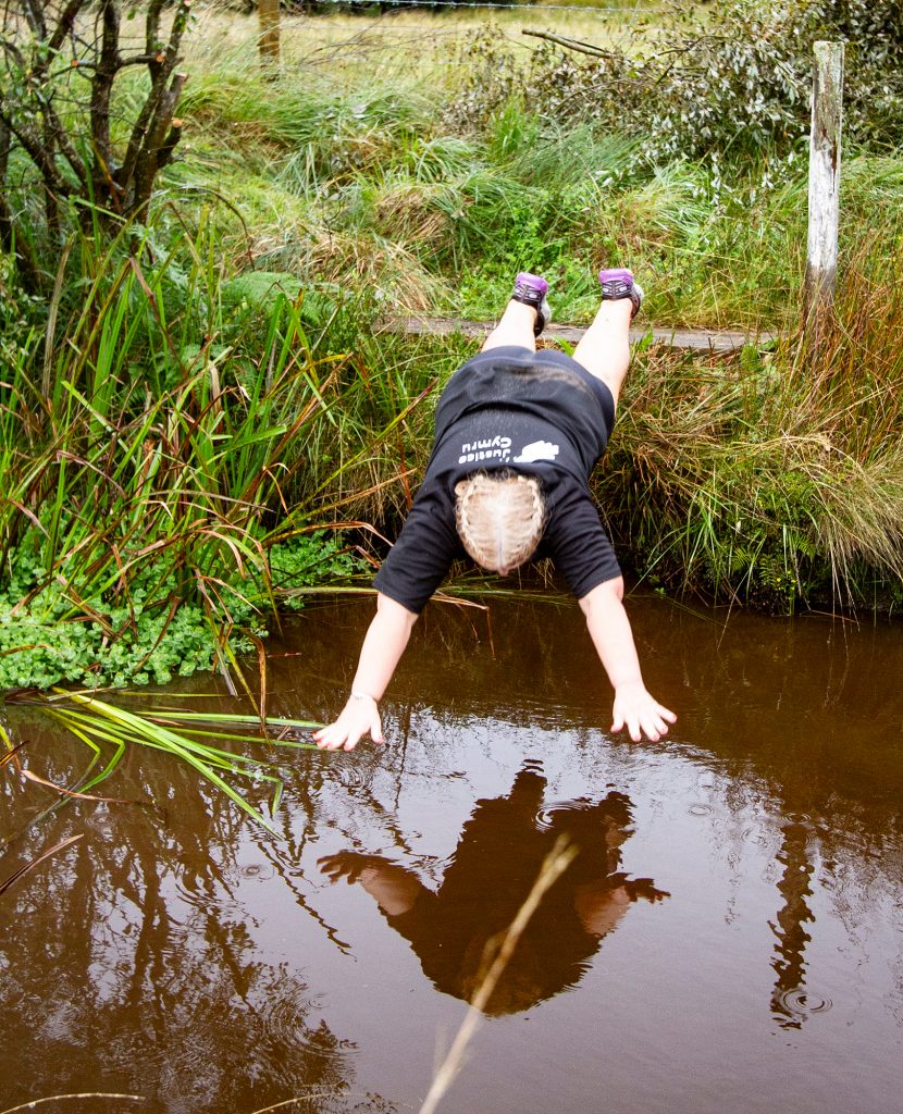 Woman diving into the ditch at the Bogathlon