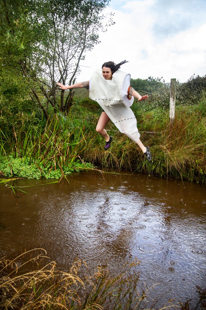 Woman jumping across a ditch at the Bogathlon