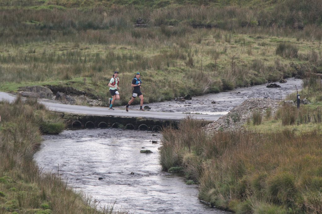 two runners crossing a bridge over the River Irfon