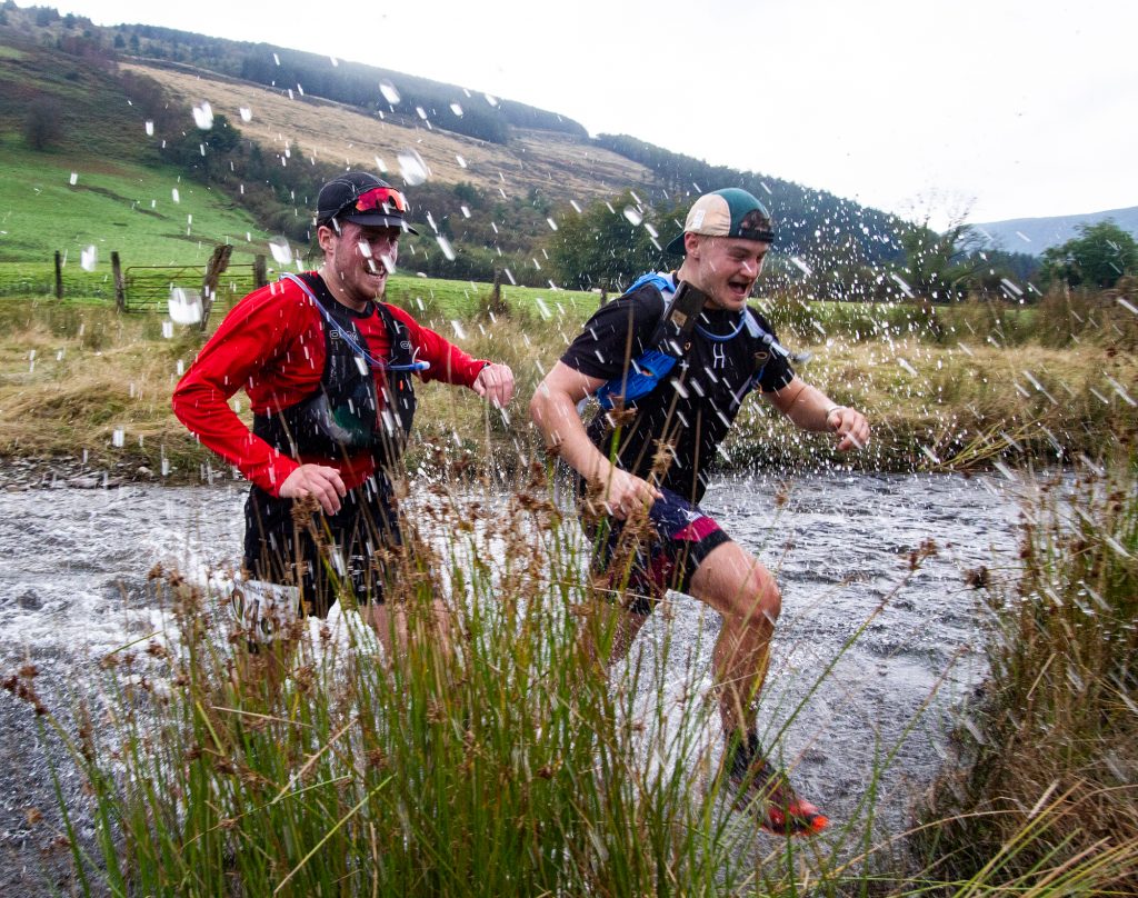 Two runners crossing a ford at Abergwesyn